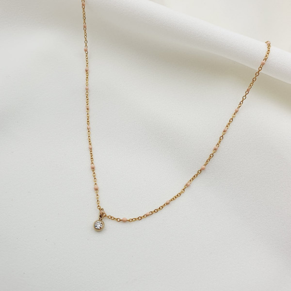 photo à plat d'un bijou femme de type collier moerani émail rose nude strass chaîne simple acier doré
